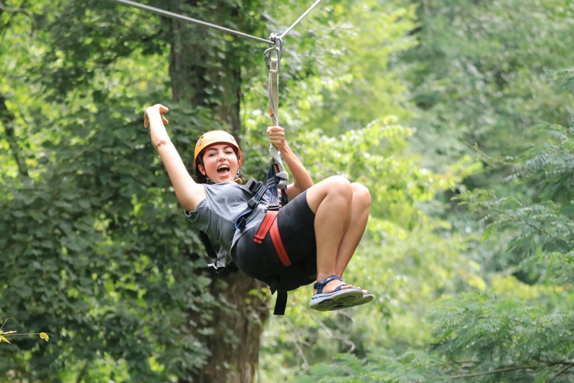 Adult female smiling and riding a scenic Maryville zipline canopy tour at Wahoo Ziplines