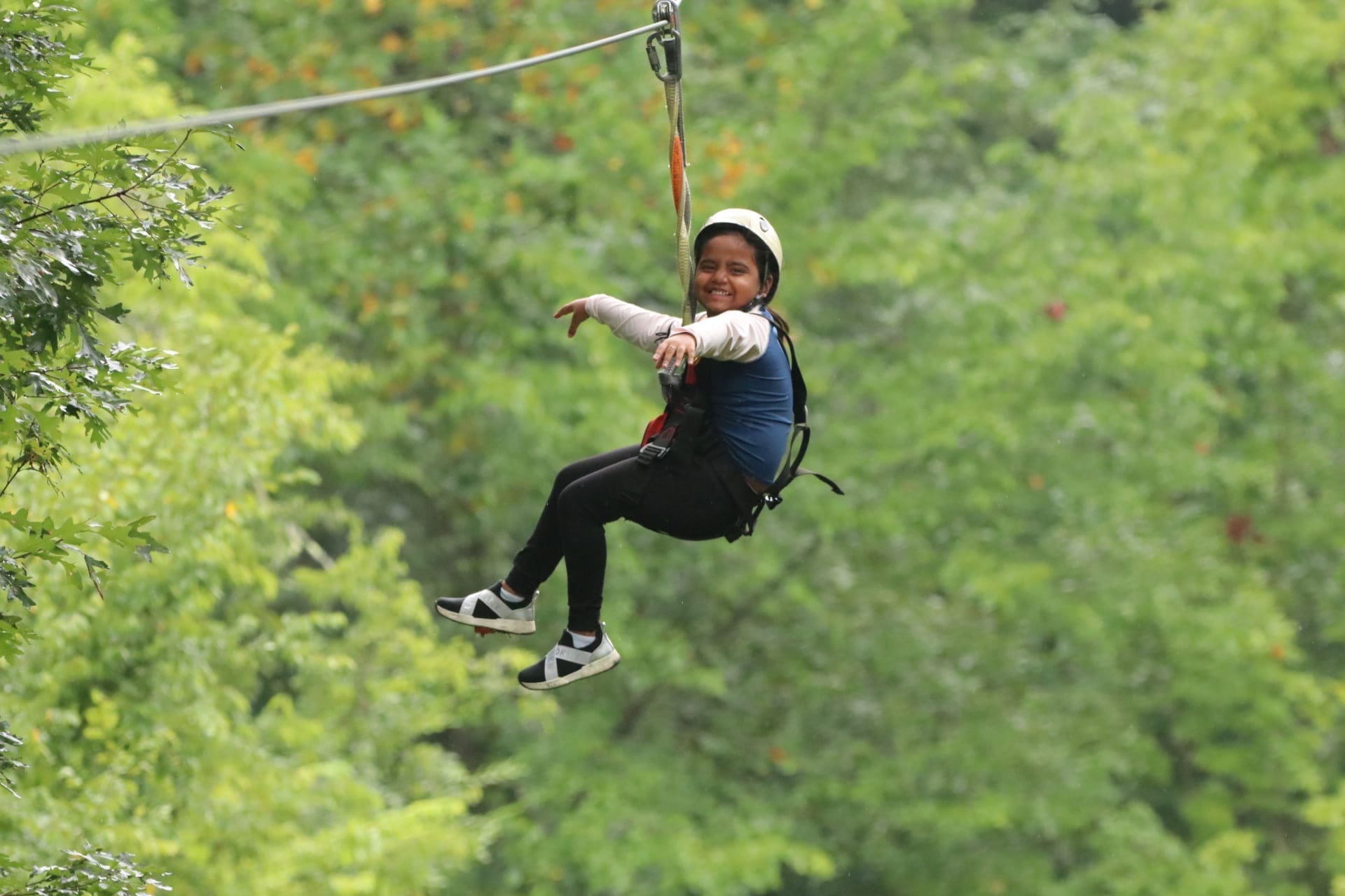 Child letting go and having fun on a Townsend zipline canopy tour at Wahoo Ziplines